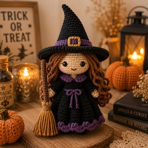 May include: A crocheted witch doll with long brown hair, wearing a black pointed hat with a purple band and gold buckle, and a black dress with purple trim and a waist tie. The doll holds a small brown yarn broomstick in its right hand.
