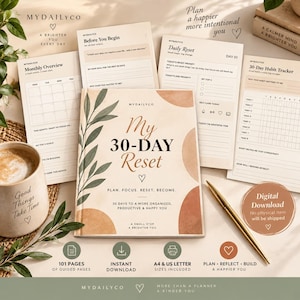 May include: A MyDailyCo 30-Day Reset planner with a beige cover featuring abstract shapes and a green leaf illustration. The planner includes pages for monthly overviews, daily resets, and habit tracking, accompanied by a gold pen and a mug.
