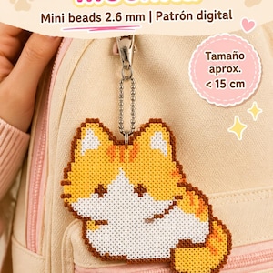 May include: A backpack charm made of 2.6 mm mini beads shaped like a cat with orange and white fur. The charm hangs from a silver-toned metal ball chain. Text on the image includes Colgante para mochila, Mini beads 2.6 mm, Patrón digital, and Tamaño aprox. < 15 cm.