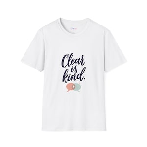 May include: A white short-sleeve t-shirt featuring the dark blue text Clear is kind. in a cursive script font. Below the text are two overlapping speech bubbles in muted pink and light green, with a small four-pointed star in the center.