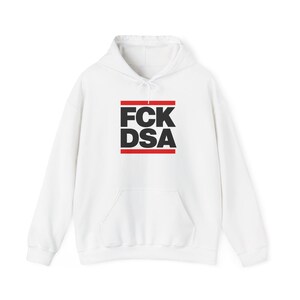 Può includere: Una felpa bianca con cappuccio e maniche lunghe caratterizzata da una grafica frontale con il testo nero FCK DSA disposto su due righe, racchiuso tra due barre rosse orizzontali. Il capo presenta un cappuccio con coulisse e una tasca a marsupio.