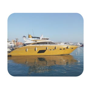 Könnte beinhalten: Eine elegante Motoryacht mit einem leuchtend goldenen Rumpf und einer weißen Oberdeckstruktur. Das Schiff ist mit mehreren ovalen Bullaugen an der Seite, weißen zylindrischen Fendern und einem Radardom auf dem Kabinendach ausgestattet.