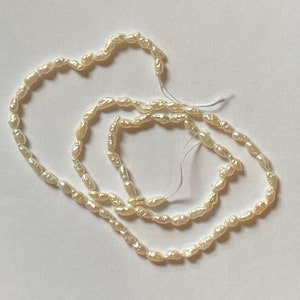Perles de riz croustillantes. Sur fil de 15,75 po. 3 x 5 mm. Très brillant.