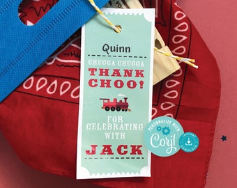 May include: A blue and white train-themed thank you tag with the text "Quinn CHUGGA CHUGGA THANK CHOO! FOR CELEBRATING WITH JACK" and a small train illustration. The tag is tied with twine to a red bandana with white polka dots.