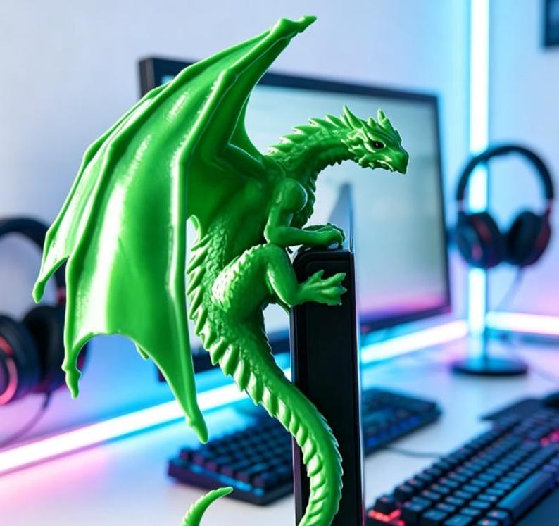 Pode incluir: Uma estatueta de drag&atilde;o verde brilhante em tr&ecirc;s dimens&otilde;es pousada na borda superior de um monitor de computador. O drag&atilde;o apresenta escamas detalhadas, grandes asas estendidas para cima e uma longa cauda curva que pende pela lateral da tela.