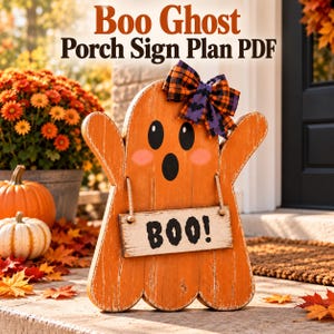 May include: A wooden orange ghost-shaped sign with black eyes and a surprised mouth, featuring pink cheeks and a hanging rectangular sign that reads BOO! in black letters. The ghost is decorated with a plaid purple and orange bow at the top.