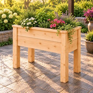 Op de afbeelding: Een rechthoekige verhoogde plantenbak gemaakt van lichtgekleurd natuurlijk hout met vier stevige poten. De bak is gevuld met een verscheidenheid aan groene kruiden, witte margrietachtige bloemen, roze bloesems en paarse bloeiende planten.