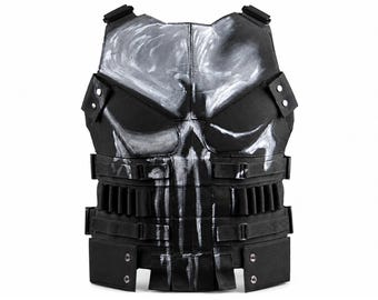 May include: A black tactical vest featuring a large, hand-painted white skull graphic on the front. The vest includes adjustable side straps, multiple integrated loops for gear, and reinforced panels with silver-toned metal rivets at the lower hem.