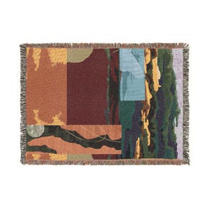 May include: A rectangular woven throw blanket featuring an abstract composition of color blocks in shades of terracotta, deep burgundy, forest green, mustard yellow, and light blue, finished with a fringed edge on all four sides of the fabric.