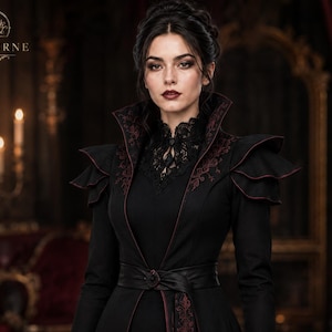 Close-up of gothic steampunk coat showing structured high collar, burgundy embroidery, layered shoulders, lace neckline and waist belt.