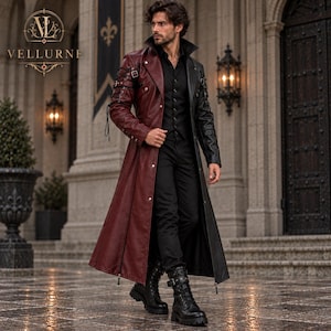 Puede incluir: Un abrigo largo de dos tonos con el lado derecho en color burdeos intenso y el izquierdo en negro, con cuello estructurado, botones de metal plateado y correas con hebillas decorativas en las mangas, sobre una camisa y pantalones de color negro.