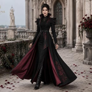 Dark queen gothic costume with flowing black and burgundy vampire coat, Victorian embroidery and dramatic long-length movement.