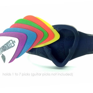 May include: A black guitar pick holder bracelet with a heart-shaped opening. The bracelet holds a stack of colorful guitar picks, including red, orange, yellow, green, blue, and purple. The text "PickBandit" is printed on the white guitar pick.
