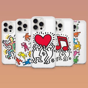 May include: Five white smartphone cases featuring colourful Keith Haring-style graphic illustrations. The designs include black line-art figures in various poses, a large red heart, a red musical note, and small figures in yellow, blue, orange, and pink.