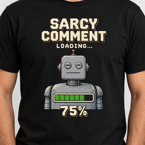 May include: A black t-shirt featuring a graphic of a grey robot with a loading bar at 75 per cent. Above the robot, the text reads SARCY COMMENT LOADING in a pixelated font. The robot has a square head, circular eyes, and a flat mouth expression.