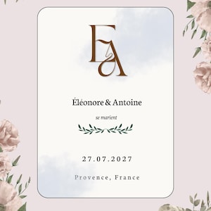 Peut inclure: Une carte d'invitation de mariage rectangulaire avec un monogramme EA en marron, le texte Éléonore & Antoine se marient, un motif de feuilles vertes, la date 27.07.2027 et le lieu Provence, France, encadrée par des roses aquarelles roses.