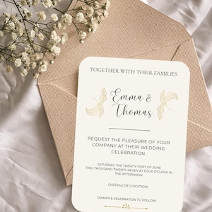 Peut inclure: Une carte d'invitation de mariage crème aux coins arrondis, présentant les noms Emma & Thomas, des illustrations de feuilles dorées et un texte détaillant une célébration le samedi 21 juin 2027 à seize heures, posée sur une enveloppe beige texturée.