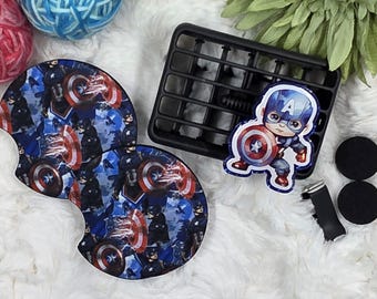 May include: Captain America-themed car accessories. Includes two car coasters with a Captain America shield design, a Captain America air vent clip, and two black car vent magnets. The coasters and air vent clip feature a blue and red color scheme.