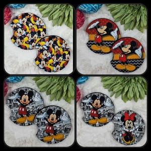 May include: Set of four round car coasters featuring different Mickey Mouse designs. One coaster features a black and white comic book style Mickey Mouse, another features a red, yellow, and black Mickey Mouse with a red bow, another features a red, yellow, and black Mickey Mouse with a black and white chevron pattern, and the last features a red, yellow, and black Mickey Mouse with a black and white polka dot pattern.