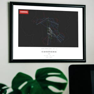 May include: A framed print featuring a dark gray map of the Cardrona ski resort in New Zealand. The map displays various ski trails in red, blue, and white lines against a dark background, with the text Cardrona and geographic coordinates below.
