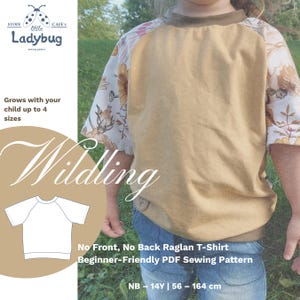 May include: A raglan t-shirt with a solid tan front panel and short sleeves featuring a white floral pattern. The shirt has a tan crew neckline and a small brown circular patch at the bottom hem. Text includes "Stoff Little Ladybug," "Wildling," and "No Front, No Back Raglan T-Shirt Beginner-Friendly PDF Sewing Pattern."