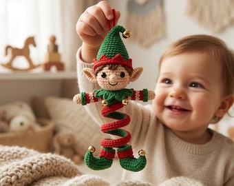 Puede incluir: Un adorno de elfo tejido a ganchillo con un gorro puntiagudo verde con un cascabel dorado, cara beige con mejillas rosadas y un cuerpo en espiral rojo y verde. El elfo tiene zapatos puntiagudos verdes con cascabeles dorados en las puntas.