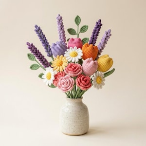 May include: A crochet flower bouquet featuring purple lavender stalks, white and yellow daisies, pink and red roses, and orange and yellow tulips. The flowers are arranged in a speckled, off-white ceramic vase with a rounded base and narrow neck.