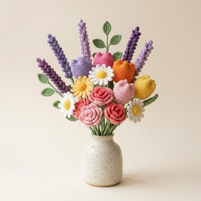 May include: A crochet flower bouquet featuring purple lavender stalks, white and yellow daisies, pink and red roses, and orange and yellow tulips. The flowers are arranged in a speckled, off-white ceramic vase with a rounded base and narrow neck.