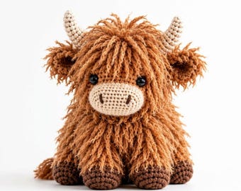 Puede incluir: Un peluche de vaca Highland tejido a ganchillo con pelaje de hilo largo y peludo de color marrón jengibre, un hocico color crema, dos cuernos pequeños color crema, pezuñas marrón oscuro y dos ojos redondos de plástico negro sobre fondo blanco.