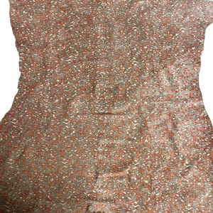 Könnte beinhalten: Ein ärmelloses Kleid mit einem sich wiederholenden Muster aus kleinen, unregelmäßigen orangefarbenen und grauen Formen auf hellem Grund. Das Kleidungsstück hat einen geraden Ausschnitt und eine körpernahe Silhouette bis zum Saum.
