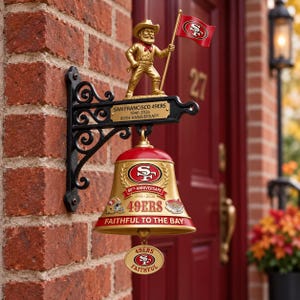 Könnte beinhalten: Eine wandmontierte Glocke zum 80-jährigen Jubiläum der San Francisco 49ers mit einer goldfarbenen Glocke, dem Teamlogo, dem Text 49ERS FAITHFUL TO THE BAY und einer goldenen Prospektor-Figur mit Flagge. Eine Plakette zeigt SAN FRANCISCO 49ERS 1946-2026.