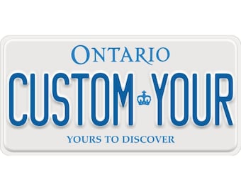 May include: A rectangular white vehicle registration plate with blue lettering. The top displays ONTARIO, the centre features the text CUSTOM-YOUR with a small blue crown icon between the words, and the bottom reads YOURS TO DISCOVER in blue capital letters.
