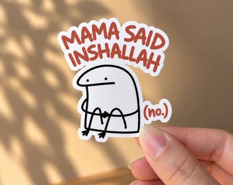 May include: A white die-cut sticker featuring a simple black line drawing of a cartoon character with a flat head and two dots for eyes. Above the character, the text MAMA SAID INSHALLAH is printed in red, with the word (no.) in red to the right.