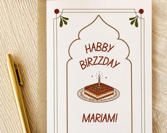 May include: A white rectangular greeting card featuring a brown arched frame with green corner accents. The text reads HABBY BIRZZDAY MARIAM! above an illustration of a square chocolate cake on a plate with a single lit candle and sparkles.