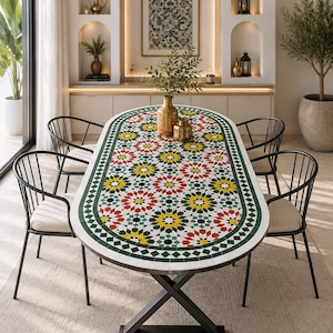 Puede incluir: Una mesa de comedor ovalada con un tablero de mosaico colorido con patrones geométricos de estrellas en rojo, amarillo, verde y negro. La mesa tiene una base de metal negro en forma de X y cuatro sillas de metal negro con cojines beige.