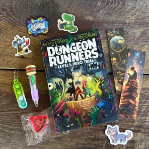 May include: A copy of the book Dungeon Runners Level 1: Hero Trial, a green pop-it keychain, a multi-colored pen with a burger topper, a watermelon-shaped eraser in plastic packaging, two bookmarks, and five stickers featuring a wolf, elephant, and dinosaur.