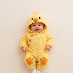 May include: A bright yellow crocheted baby onesie featuring a hood with a small orange beak and black eyes, resembling a duckling. The garment has three brown buttons along the side and two orange crocheted duck feet appliqués on the legs.
