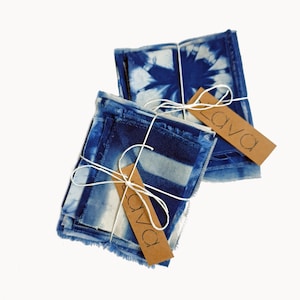 May include: A set of four indigo blue fabric squares with frayed edges, tied together with twine and a brown paper tag that reads "lava".