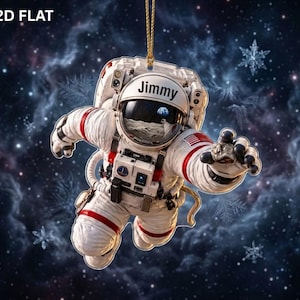 May include: A flat, hanging ornament featuring an astronaut in a white suit with red accents, floating against a dark space background with snowflakes. The helmet visor reflects a lunar landscape and the Earth, with the name Jimmy printed above.