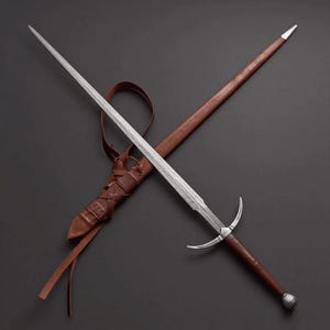 May include: A long, double-edged steel sword with a pointed tip, a silver crossguard, and a brown leather-wrapped handle ending in a rounded pommel. It is positioned diagonally across a matching brown leather scabbard with leather lacing details.