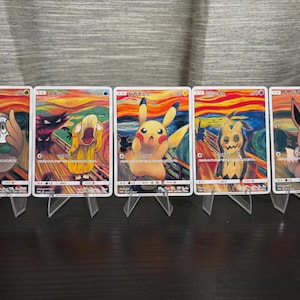 May include: Five rectangular trading cards featuring Pokémon characters in a style inspired by The Scream painting. Each card displays a unique creature, including Rowlet, Psyduck, Pikachu, Mimikyu, and Eevee, set against a swirling orange and blue background.