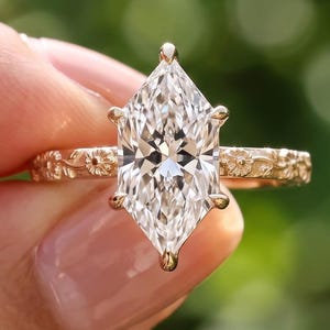 Floral engagement ring with a Dutch marquise lab grown diamond on a yellow gold band carved with daisies and vines