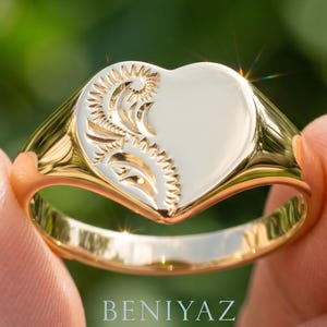 Heart signet ring for women in rose gold with vintage floral engraving on one side of the polished heart face