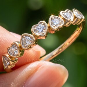 Heart eternity band with a row of heart cut lab grown diamonds in heart shaped bezels on a slim gold band