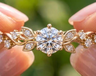 May include: A gold ring featuring a large round brilliant-cut center stone flanked by smaller round stones set within leaf-shaped metal accents along the band. The text BENIYAZ LAB GROWN is printed at the bottom of the image.