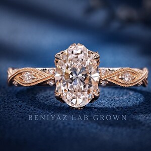 Vintage oval lab grown diamond engagement ring in rose gold with a milgrain marquise accent band and oval centre stone.