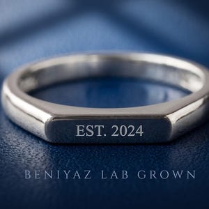 Minimalist flat top bar signet ring in polished silver tone shown from the front on a dark blue luxury background.