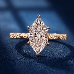 Duch Marquise lab grown diamond engagement ring in yellow gold with floral carved band and elongated center stone.