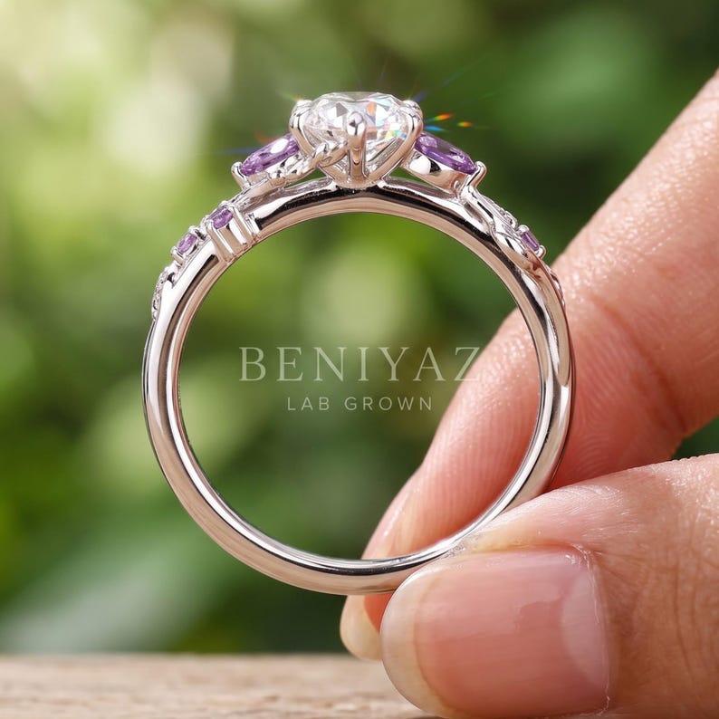 Side profile of nature inspired engagement ring showing raised Dutch marquise diamond setting, leaves, vines and purple gemstone accents.