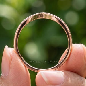 Back view of nesting wedding band showing the plain polished shank and curved chevron section at the front.